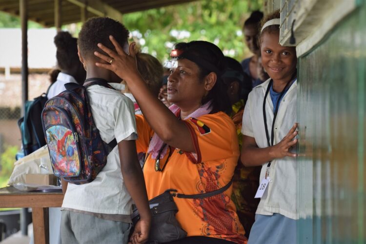 Fred Hollows Foundation Pacific trachoma lead Dr Anasaini Cama working with children in Fiji. Image: Shea Flynn/RTI International.