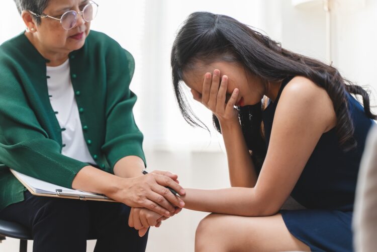 Young woman in a mental therapy session talking with a psychologist in the office.